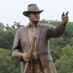 bronze sculpture of a man in a hat
