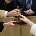 artist and donor hand small statue to Pope Francis