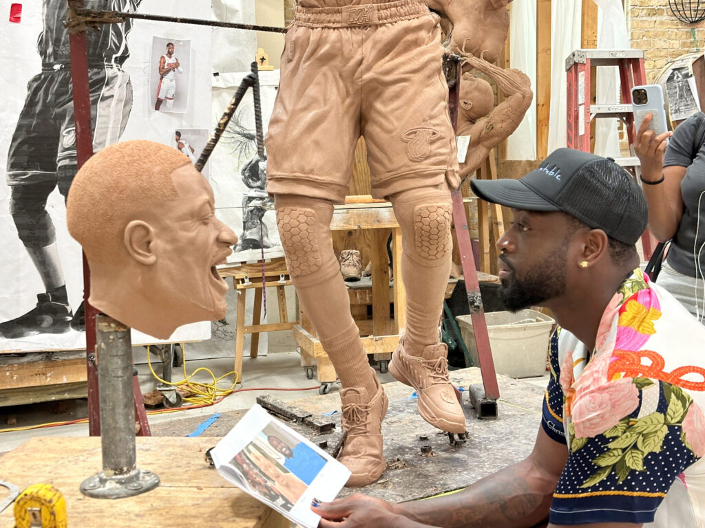 Dwyane Wade looking at clay model of himself