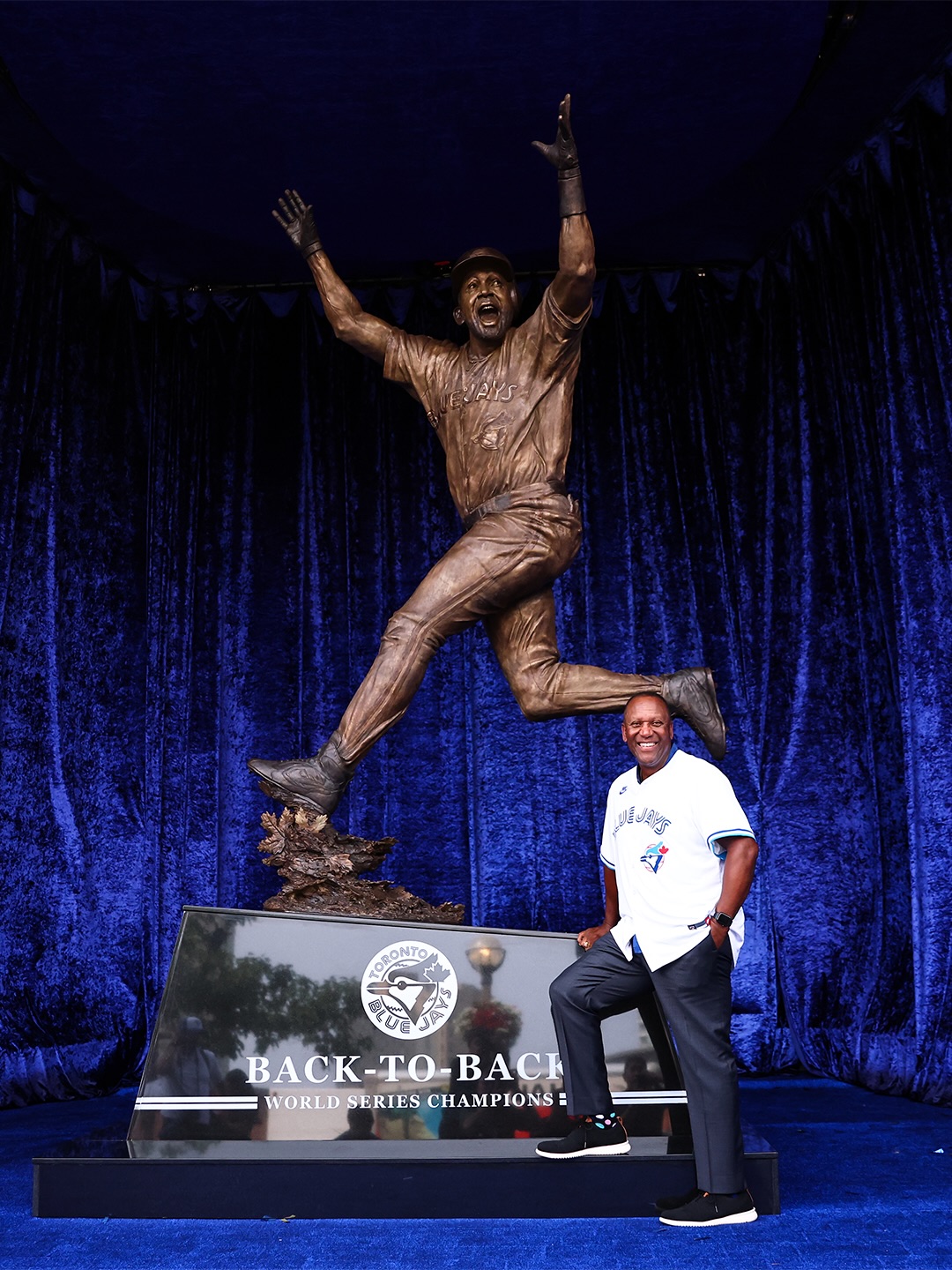 Joe carter standing next to his statue